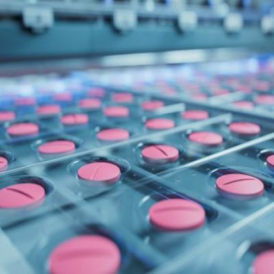 A close up image of trays of pink pills in production.